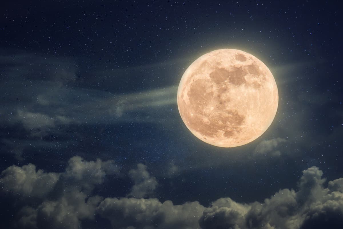 Pleine lune éclatante dans un ciel avec quelques nuages