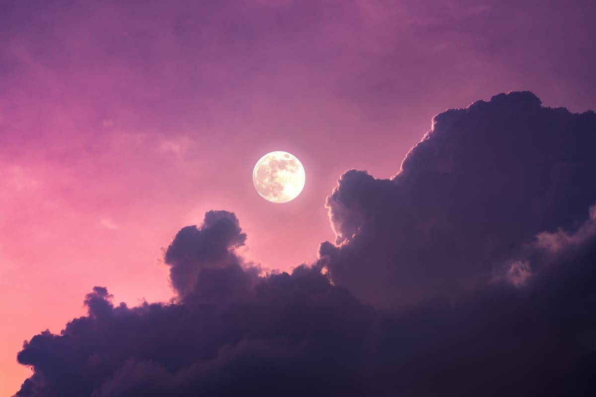 Pleine lune dans un ciel magique rose avec quelques nuages